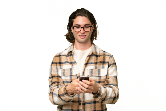 Young caucasian man isolated on green chroma background sending a message with the mobile