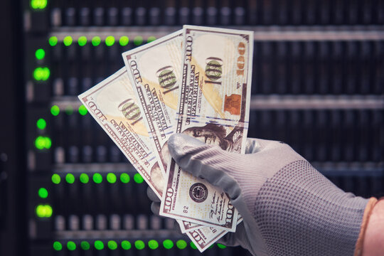 Money dollars in the hands of a man on the background of a data storage server, close-up - Powered by Adobe