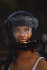 Young woman in a black motorcycle helmet.