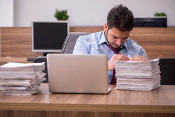 Young male employee unhappy with excessive work in the office