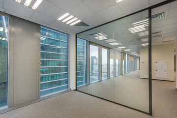 pacious office space with light walls, panoramic windows and a glass partition.