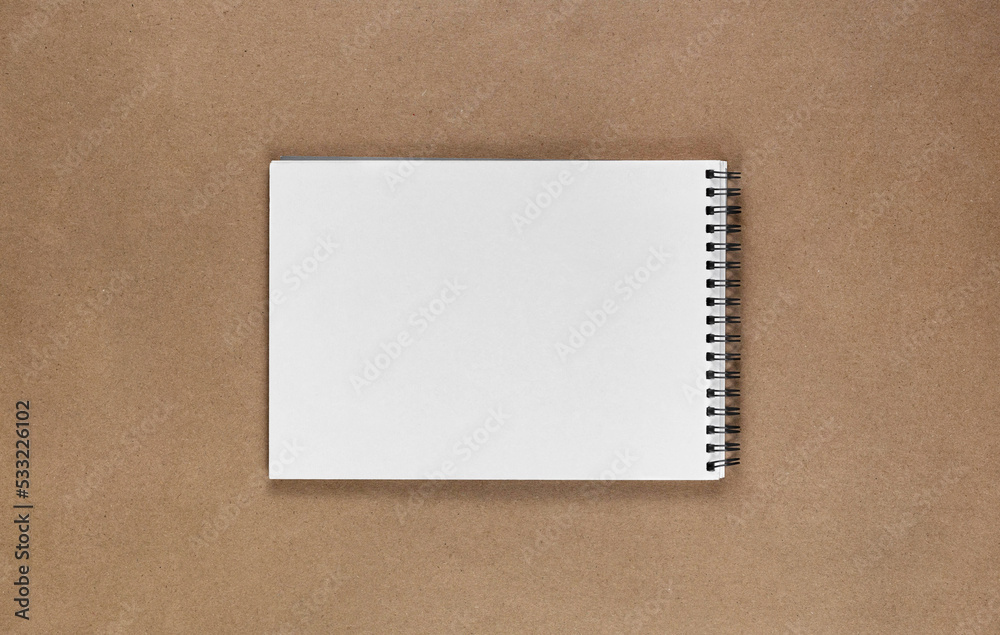 Poster A notebook in a minimal style top view with copy space for design. Isolated brown background of recycled craft vintage paper.