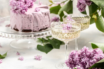Obraz na płótnie Canvas mousse cake blueberry tart. bouquet of purple blooming lilacs, French cuisine, postcard, background