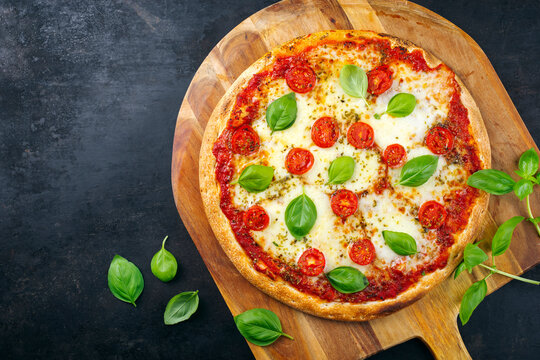 Traditionelle neapolitanisch italienische Pizza Margherita mit Tomaten und Mozzarella serviert als Draufsicht auf einer Pizza Schaufel aus Holz mit Textfreiraum 