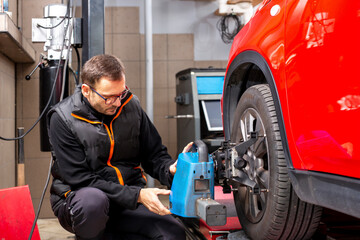 mechanic changing car wheel. Setting the alignment of the wheels. A mechanic in a car repair shop aligns the wheels