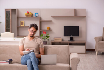 Young male employee working from house