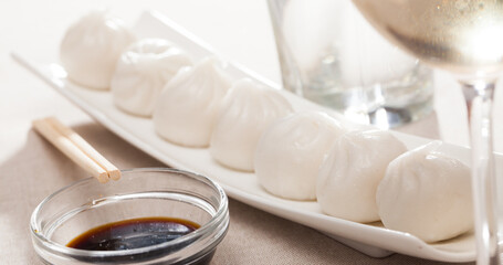 Fototapeta na wymiar Dim sum dumplings with soy sauce on white plate