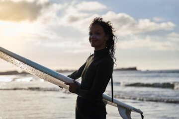 Caucasian lady with amazing smile and frizzy hair posing to the camera after surf lesson