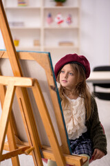 Young little girl enjoying painting at home