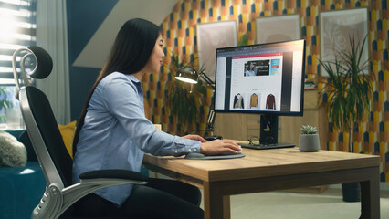 Female asian web designer using personal computer for creating website in professional constructor while working on project remotely at home. Freelance