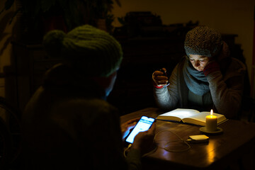 Blackout Stromausfall Heizung Bewohner mit Mütze Kerze Taschenlampe Powerbank in Haushalt warten...