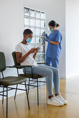 Patient using smartphone while sitting in a waiting room.