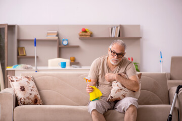 Old man doing housework at home