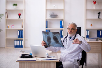 Obraz premium Old male doctor radiologist working in the clinic