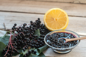 Elderberry jam, fresh berries and leaves and lemon.
