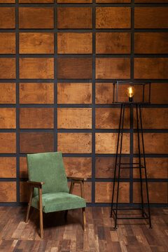 wooden armchair on the background of a wall with wooden inserts. classic photo zone with a chair for a wedding photo shoot. brown room with green armchair
