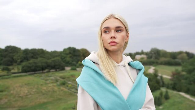 Portrait of Caucasian female model in park. A girl in a tracksuit is a bitch after a run in the park. Pusher. High quality 4k footage