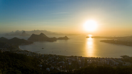 Aerial view of the sunset over Guanabara Bay from the City Park of Niterói. In the background, the mountains Pão-de-Açucar, Corcovado, and Pedra da Gávea, postcards of the city of Rio de Janeiro.