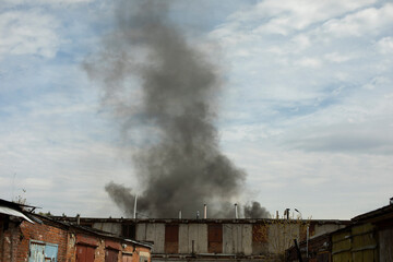 Fototapeta na wymiar Burning of building. Smoke over buildings. Smoke in sky.