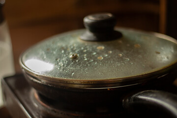 Frying pan in kitchen. Lid on frying pan. Cooking.