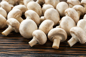 champignon mushrooms on a  brown wooden table close-up.