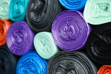 Rolls of different color garbage bags as background, closeup