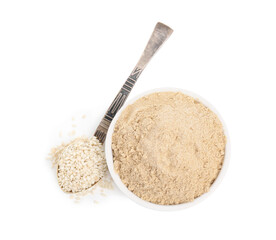 Sesame flour in ceramic bowl and spoon of seeds isolated on white, top view