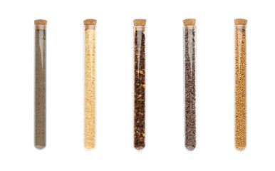 Set of glass tubes with different spices on white background, top view