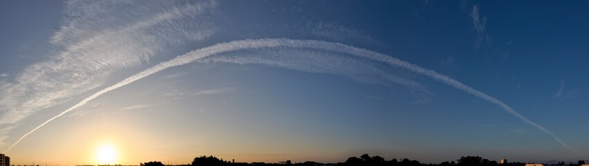 Tokyo,Japan - September 26, 2022: Airplane track or contrail drawn by a cargo jet at sunrise
