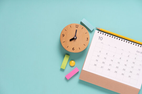 close up of calendar and alarm clock on the green table background, planning for business meeting or travel planning concept