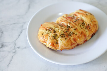 Sausage buns bread. Soft baked bun (dough) stuffed with sausage for fast food breakfast or coffee break. Sausage roll, (hot dog). With mayo, tomato sauce, mozarella cheese and parsley topping