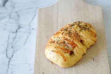Sausage buns bread. Soft baked bun (dough) stuffed with sausage for fast food breakfast or coffee break. Sausage roll, (hot dog). With mayo, tomato sauce, mozarella cheese and parsley topping