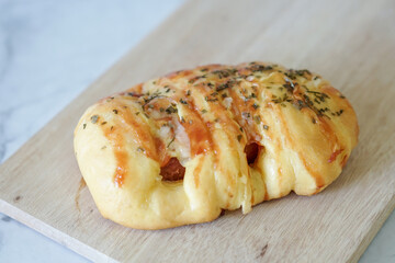 Sausage buns bread. Soft baked bun (dough) stuffed with sausage for fast food breakfast or coffee break. Sausage roll, (hot dog). With mayo, tomato sauce, mozarella cheese and parsley topping