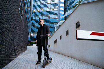 Full size body shot of urban guy with electric scooter 