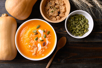 Butternut squash pumpkin soup in bowl on wooden background, Homemade food in autumn season