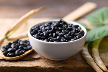 Black kidney bean seed in bowl on wooden background