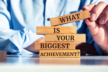 Wooden blocks with words 'What is Your Biggest Achievement?'.