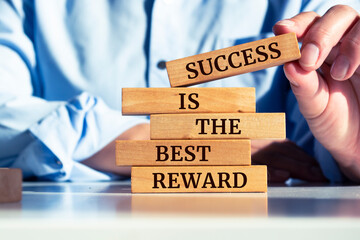 Wooden blocks with words 'Success is the Best Reward'.