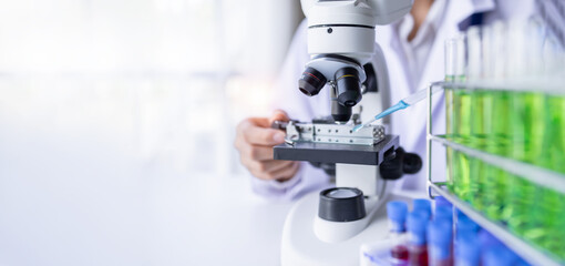 Researchers working in the clinical laboratory, shot of microscope with metal lens.