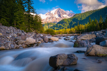 Mount Rainier, spruce forest, glacial rocks, and the Nisqually River in Mt Rainier National Park in...
