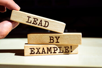 Wooden blocks with words 'Lead By Example'.