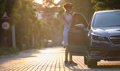 Young woman driver getting inside her car. Transportation and traffic concept