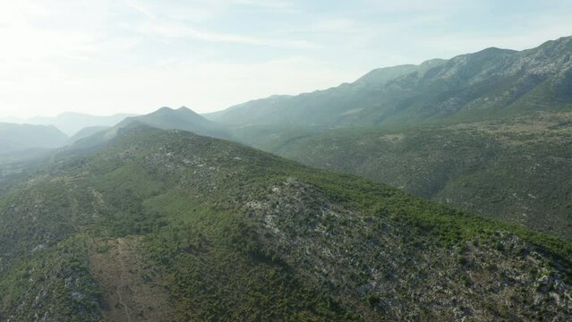 Aerial view of the landscape of the mountains of Croatia. Mountain peaks and ridges are covered with coniferous trees. High quality 4k footage