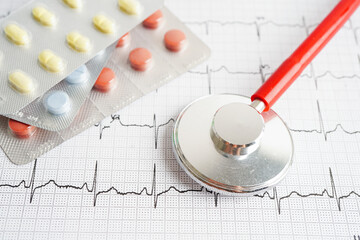 Stethoscope on electrocardiogram (ECG) with drug, heart wave, heart attack, cardiogram report.