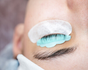 Close-up portrait of a woman in a beauty salon on eyelash lamination procedure. 