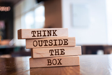 Wooden blocks with words 'Think Outside the Box'.