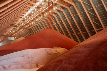 High pile of red color potassium fertilizers in storehouse