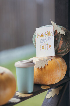 autumn coffee in a mug with pumpkins and oak leaves, on the background of the phrase from rhinestones Pumpkin spice latte