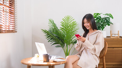 Relaxation lifestyle concept, Young Asian woman use smartphone to chatting after working at home