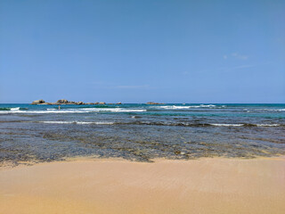 Hikkaduwa, Sri Lanka - March 8, 2022: Beautiful azure water of the Indian Ocean near the coral reef of Hikkaduwa beach. Copy space